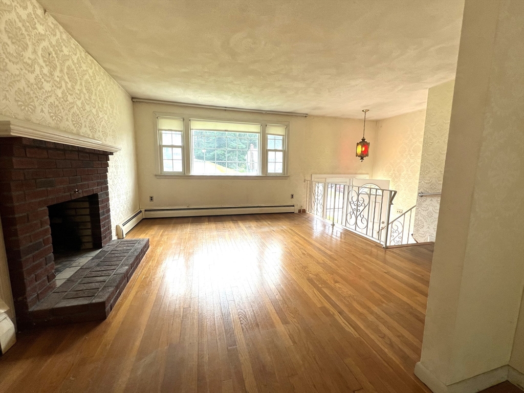 31 Dix Rd Extension Woburn, MA 01801 - Photo 3 of 22 a view of a livingroom with wooden floor a fireplace and windows