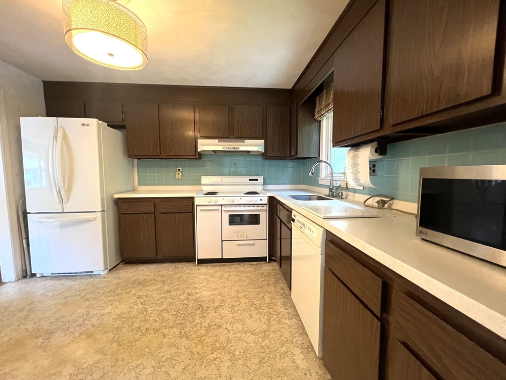 31 Dix Rd Extension Woburn, MA 01801 - Photo 6 of 22 a kitchen with a sink a stove top oven and cabinets