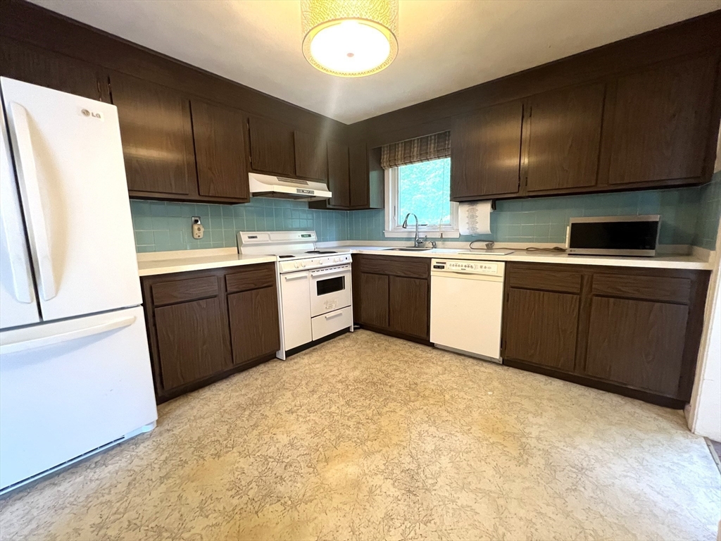 31 Dix Rd Extension Woburn, MA 01801 - Photo 7 of 22 a kitchen with a sink a stove and refrigerator