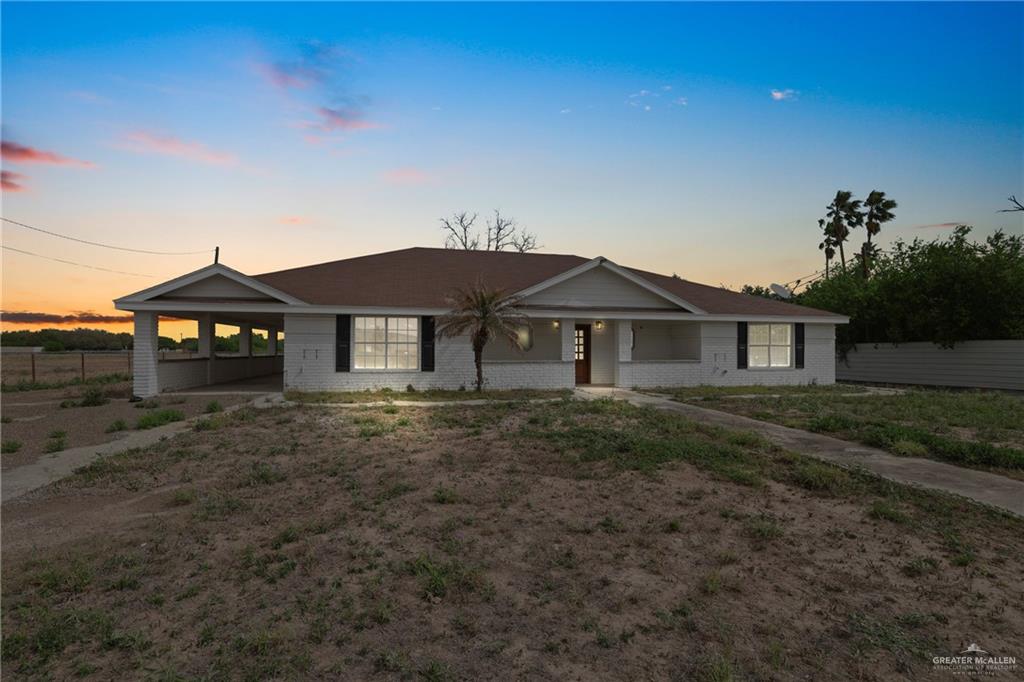 Single story home featuring brick siding, fence, and a carport