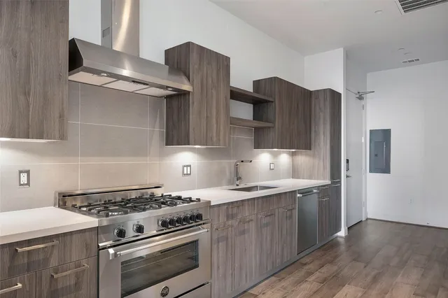 a kitchen with stainless steel appliances granite countertop a stove a refrigerator and a sink