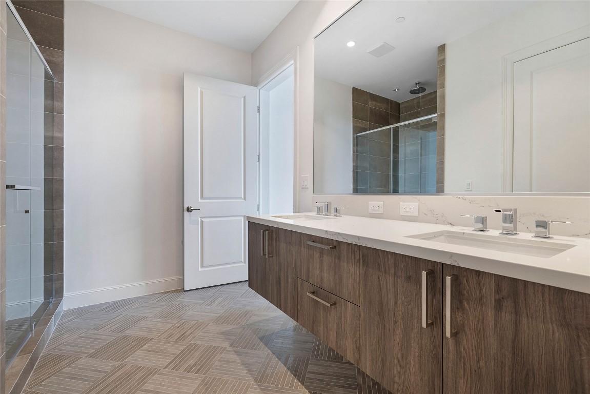 1211 Caroline Street, Unit 1102 Houston, TX 77002 - Photo 8 of 9 a bathroom with a double vanity sink and mirror