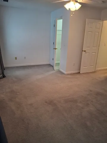 an empty room with chandelier fan