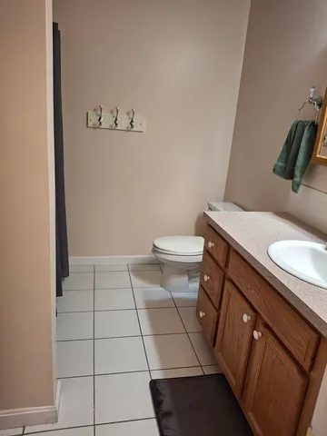 a bathroom with a granite countertop toilet and a sink