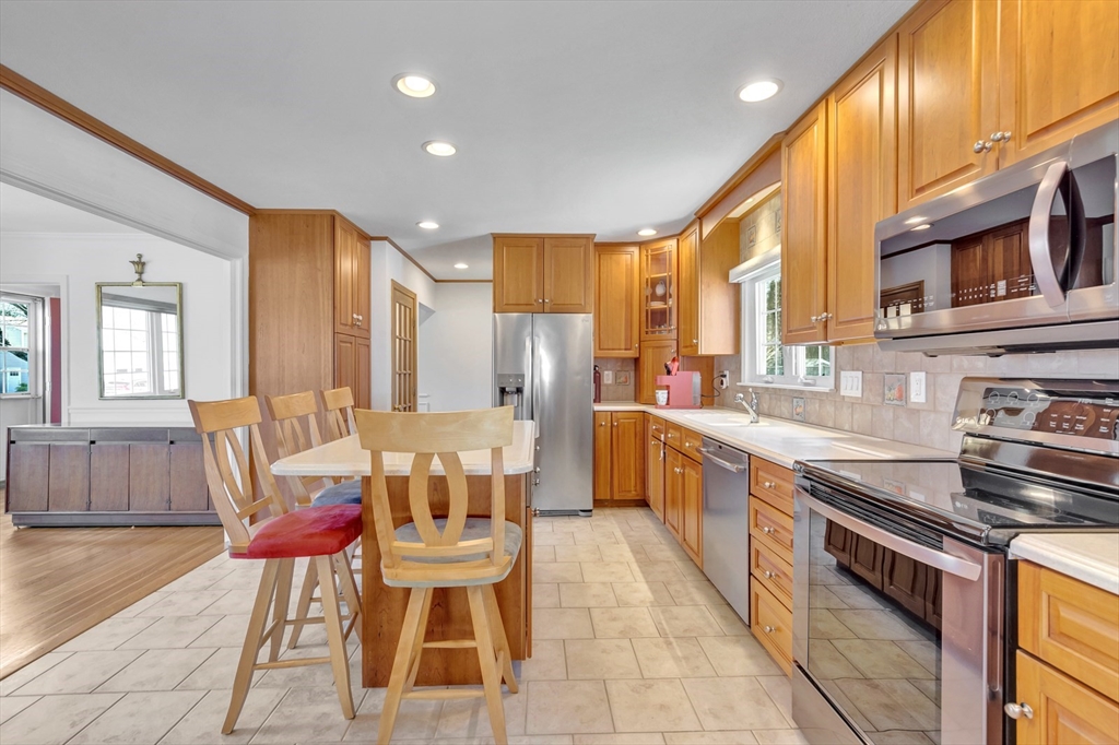 6 Blueberry Hill Road Groveland, MA 01834 - Photo 14 of 39 a large kitchen with stainless steel appliances kitchen island granite countertop a table chairs in it and a wooden floors