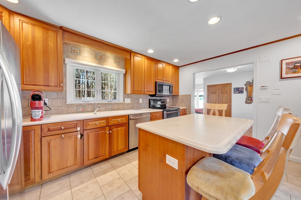 6 Blueberry Hill Road Groveland, MA 01834 - Photo 15 of 39 a large kitchen with stainless steel appliances granite countertop a sink a stove a dining table and chairs