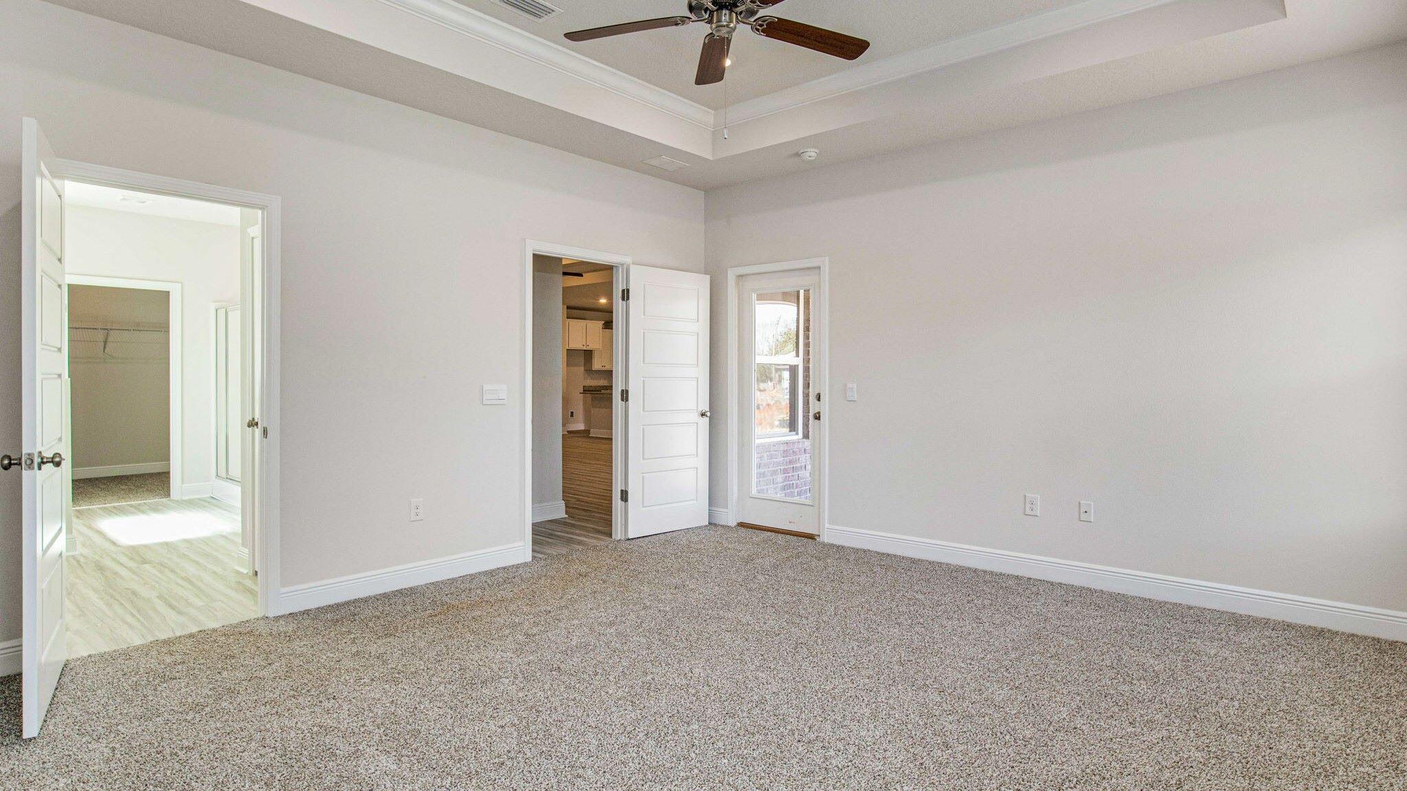8652 Bluebell Street Milton, FL 32583 - Photo 14 of 25 an empty room with a chandelier fan and windows