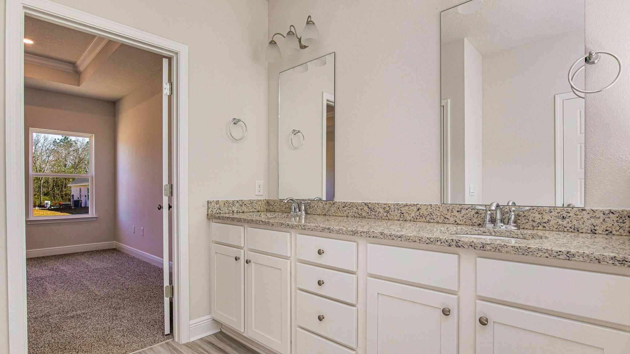 8652 Bluebell Street Milton, FL 32583 - Photo 16 of 25 a bathroom with a granite countertop sink and a mirror