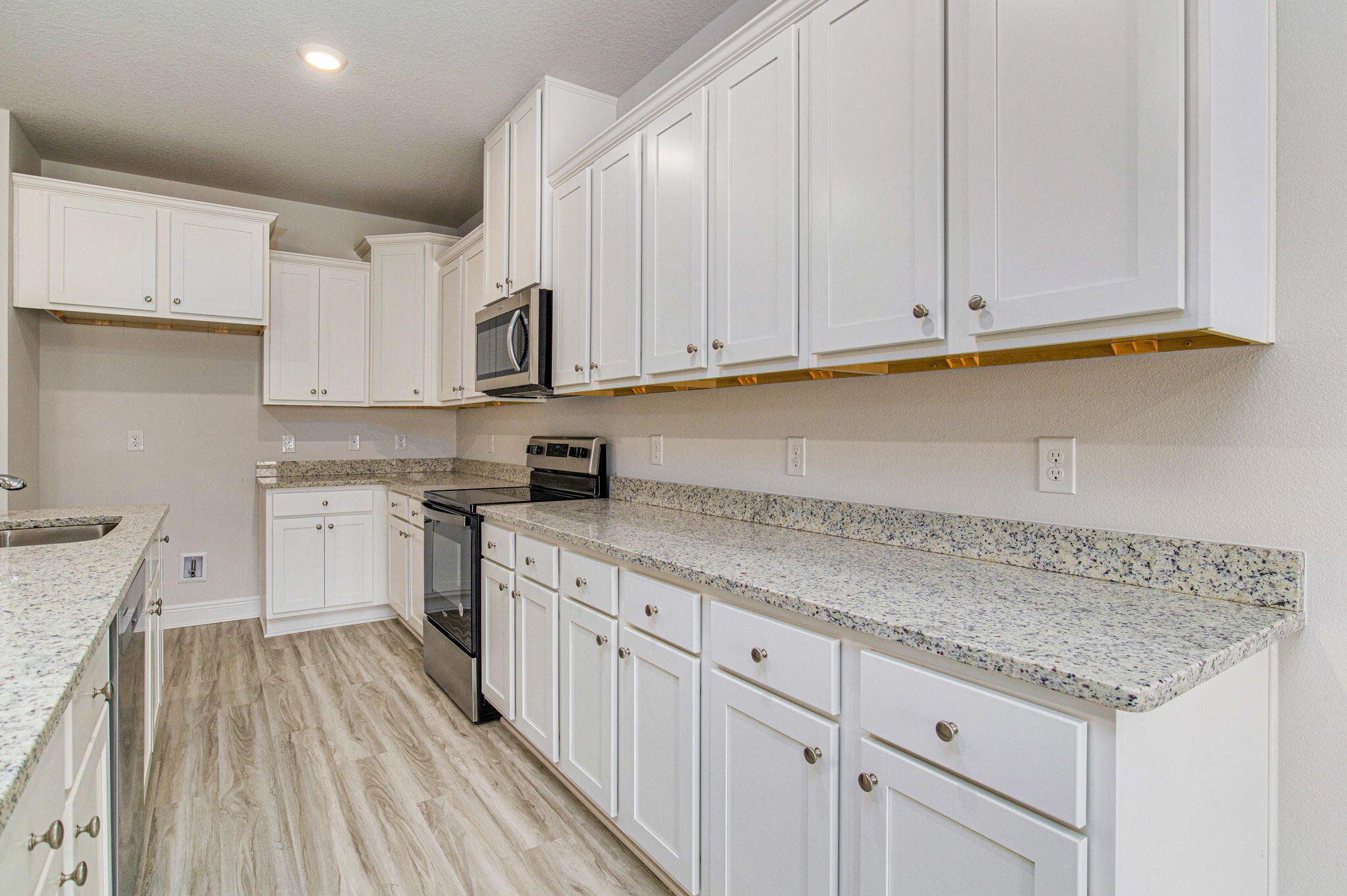 8652 Bluebell Street Milton, FL 32583 - Photo 4 of 25 a kitchen with granite countertop white cabinets and white appliances