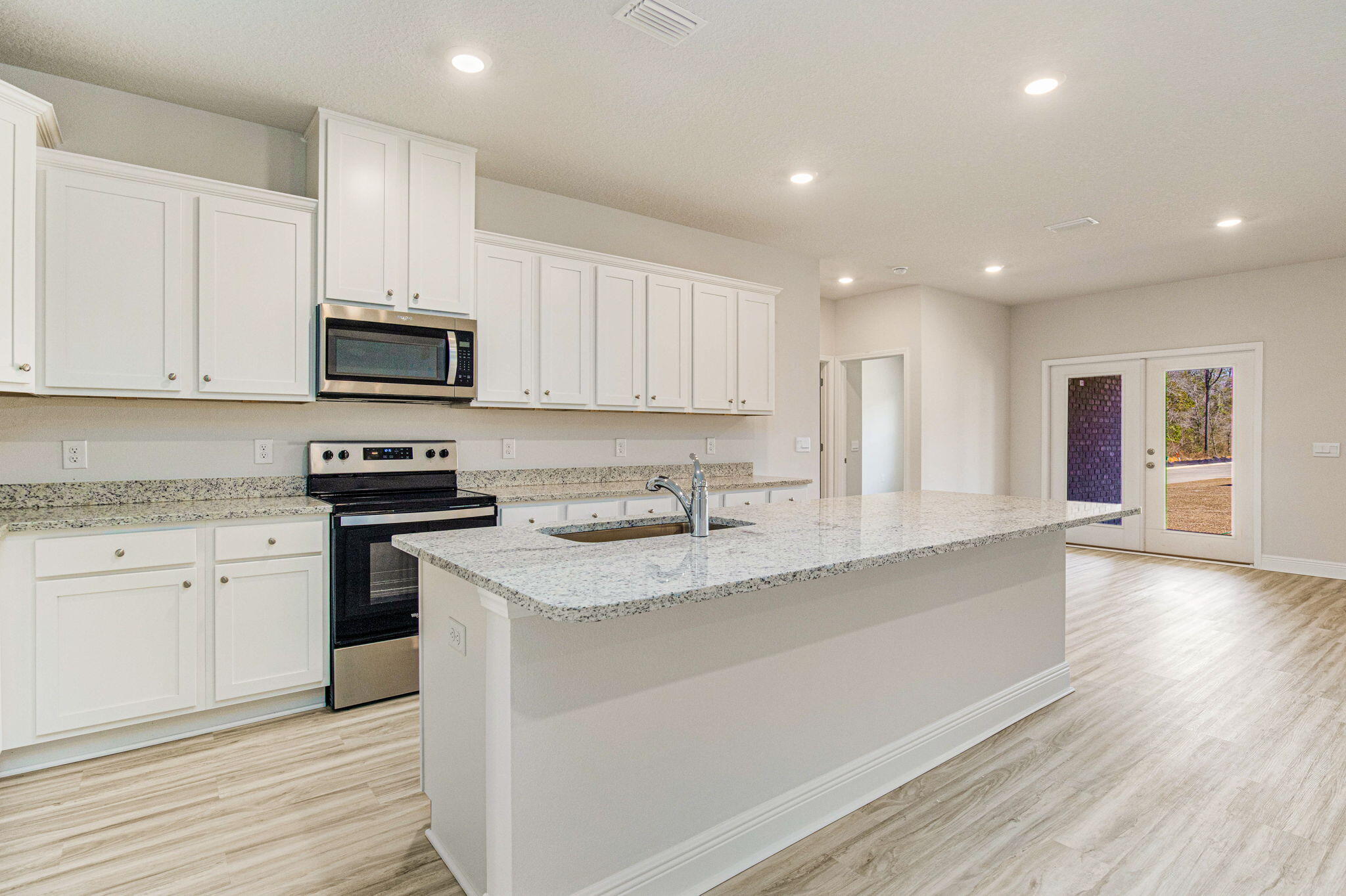 8652 Bluebell Street Milton, FL 32583 - Photo 6 of 25 a kitchen with stainless steel appliances granite countertop a sink stove microwave and cabinets