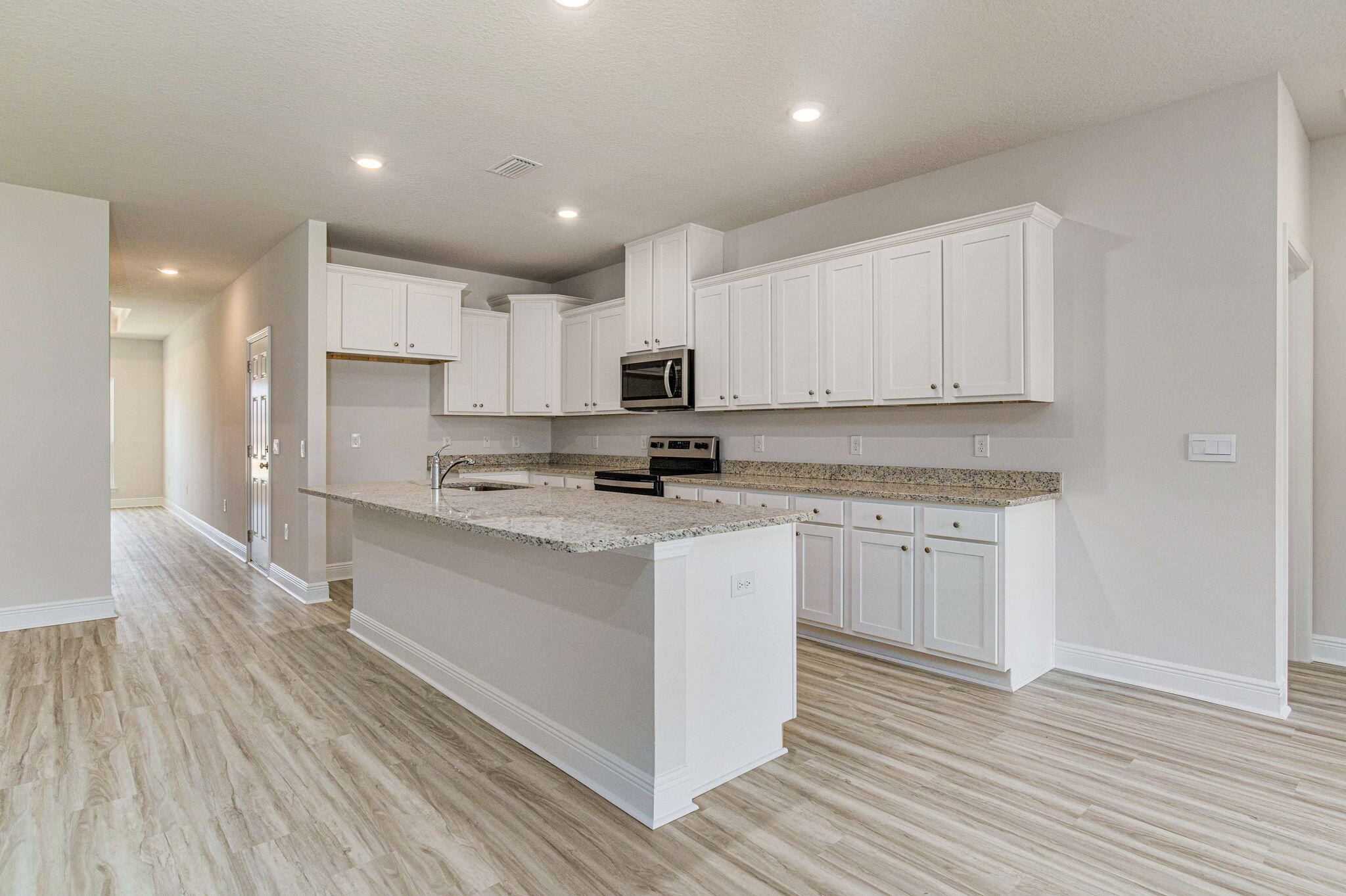 8652 Bluebell Street Milton, FL 32583 - Photo 7 of 25 a kitchen with kitchen island granite countertop a sink cabinets and wooden floor