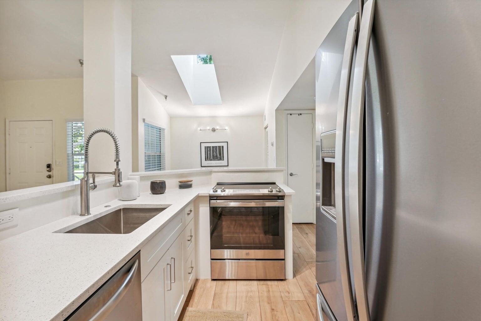 1050 Crystal Way, Unit L Delray Beach, FL 33444 - Photo 4 of 13 a kitchen with a sink and a refrigerator