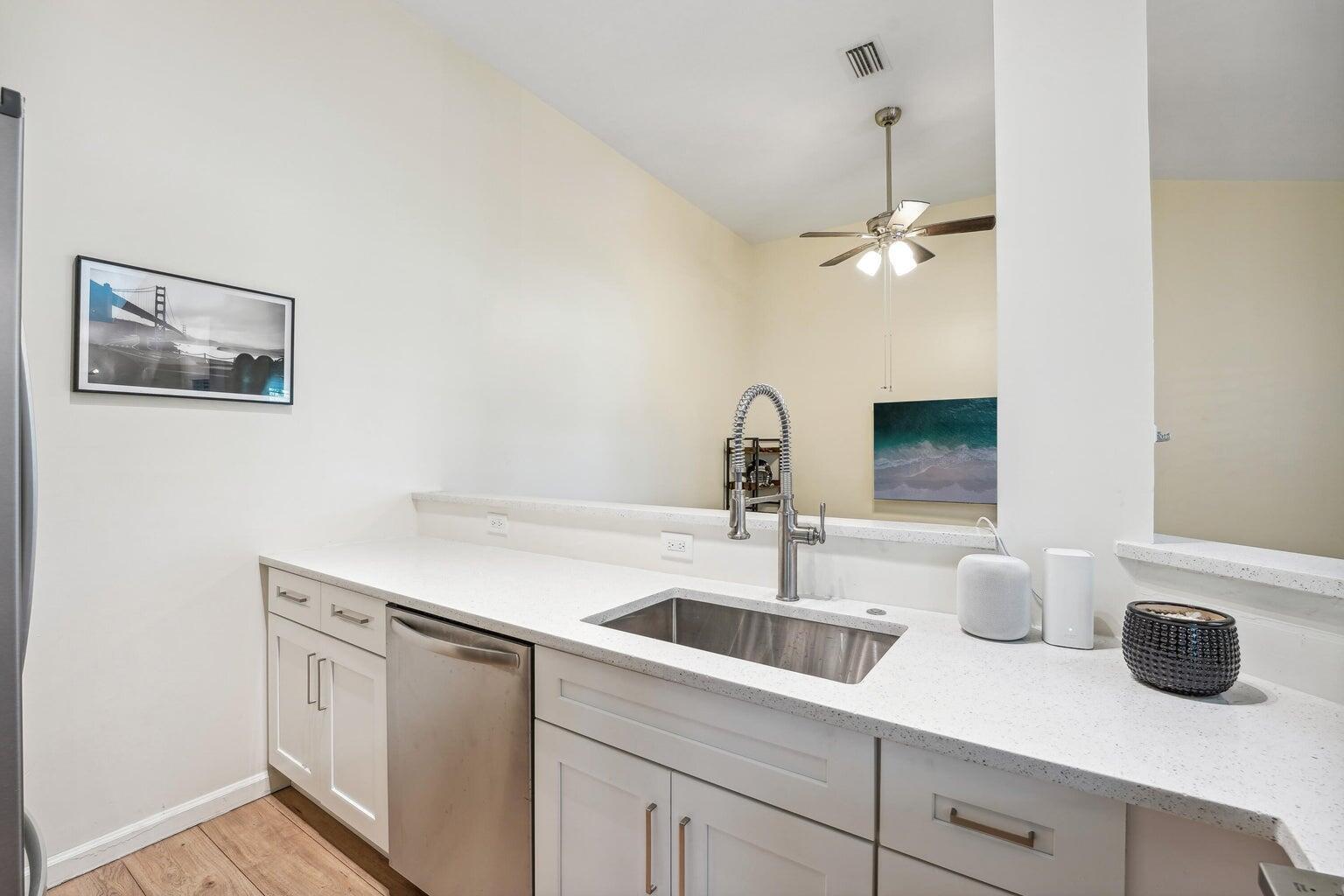 1050 Crystal Way, Unit L Delray Beach, FL 33444 - Photo 5 of 13 a kitchen with a sink and a refrigerator