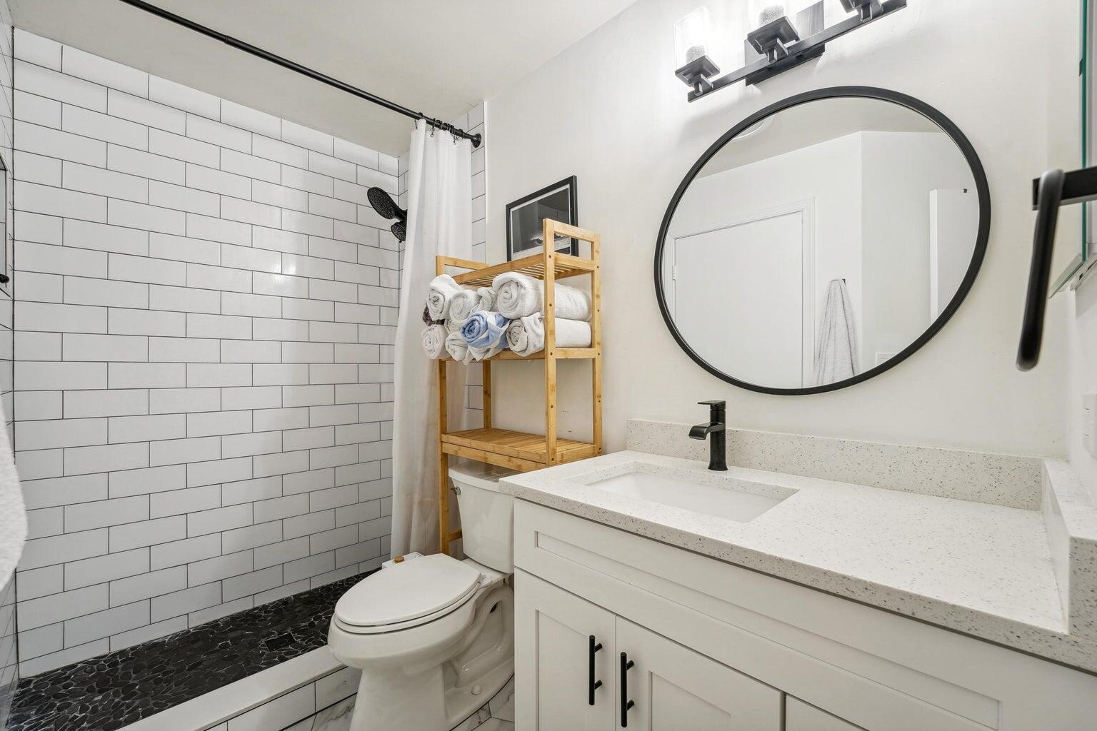 1050 Crystal Way, Unit L Delray Beach, FL 33444 - Photo 9 of 13 a bathroom with a sink a mirror a toilet and a shower