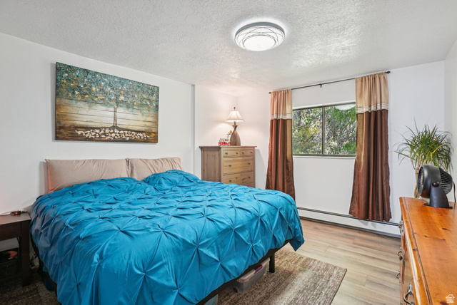 645 Swenson Avenue, Unit 3 Springville, UT 84663 - Photo 6 of 9 Bedroom featuring baseboard heating, a textured ceiling, and light wood-style flooring