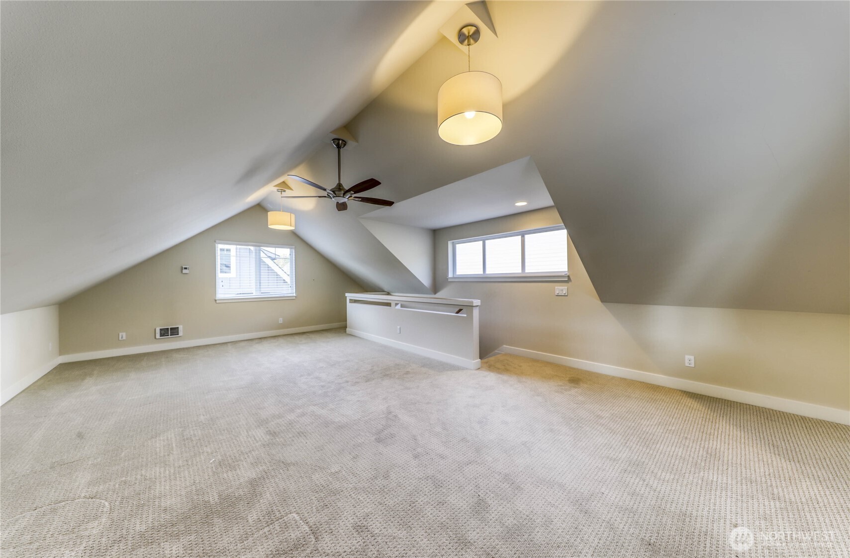 690 Wintersweet Road Northeast Bainbridge Island, WA 98110 - Photo 22 of 23 an empty room with a chandelier fan and windows