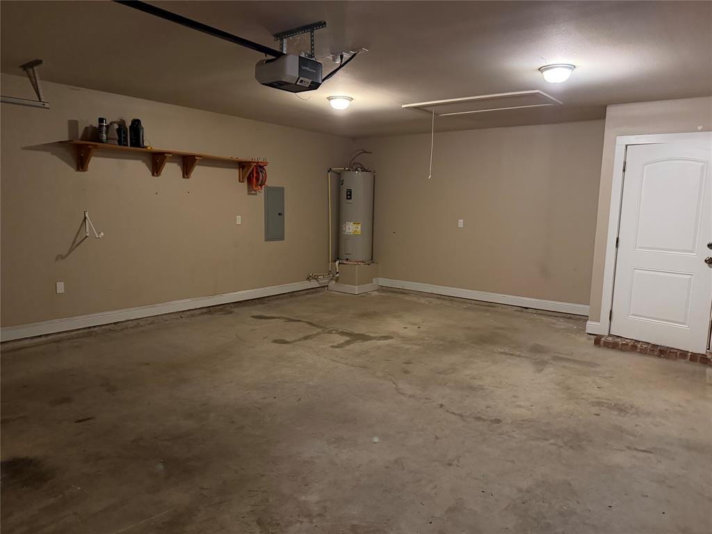 520 Big Red Circle Haughton, LA 71037 - Photo 21 of 25 Garage featuring a concrete floor, overhead lighting, a built-in shelf, and an access door
