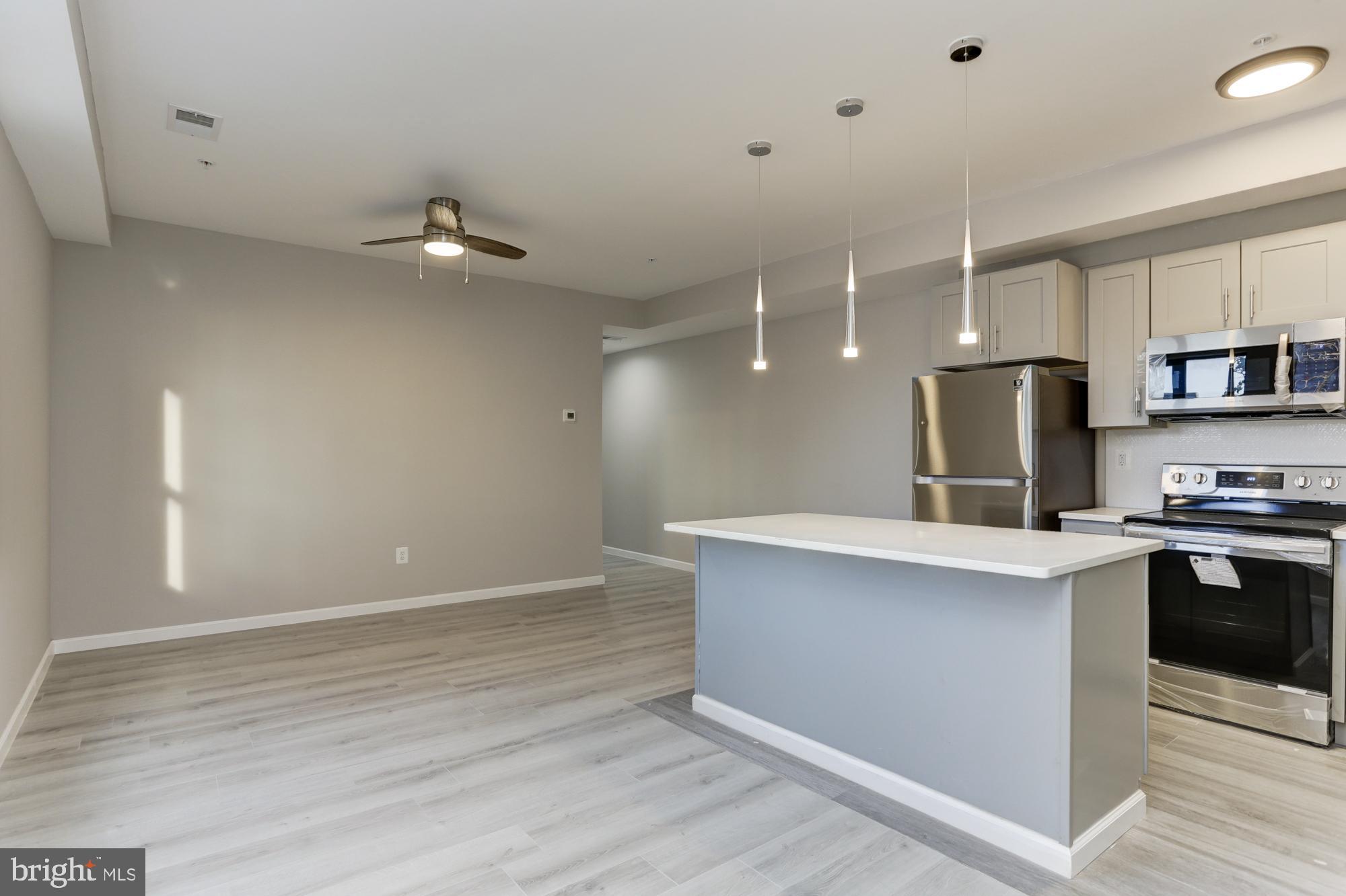 400 South Highland Avenue, Unit 301 Baltimore, MD 21224 - Photo 2 of 13 a kitchen with kitchen island a sink appliances and cabinets