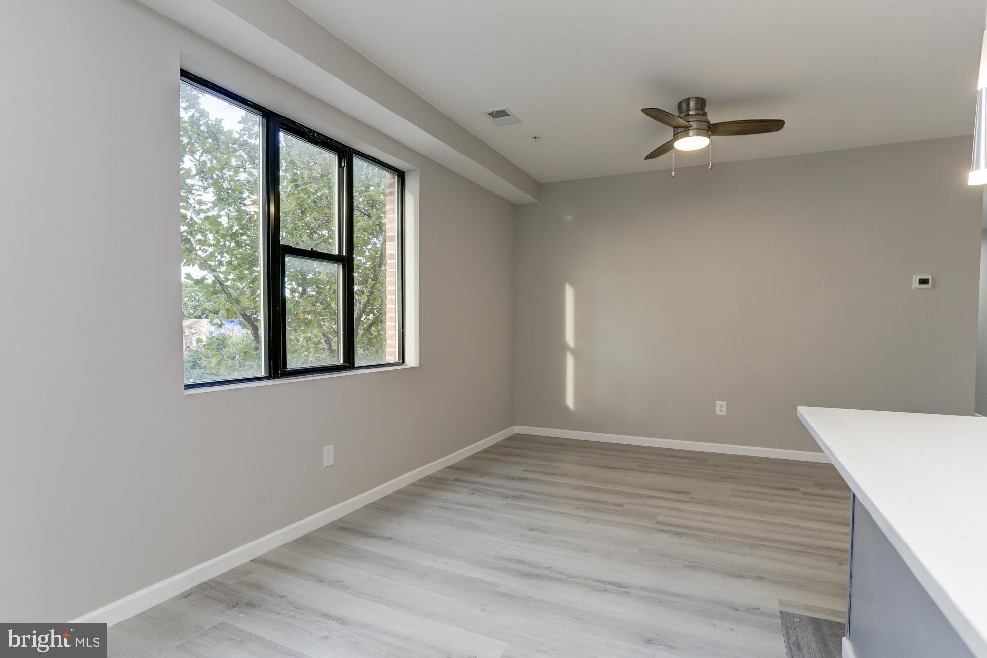 400 South Highland Avenue, Unit 301 Baltimore, MD 21224 - Photo 3 of 13 a view of an empty room with wooden floor and a window
