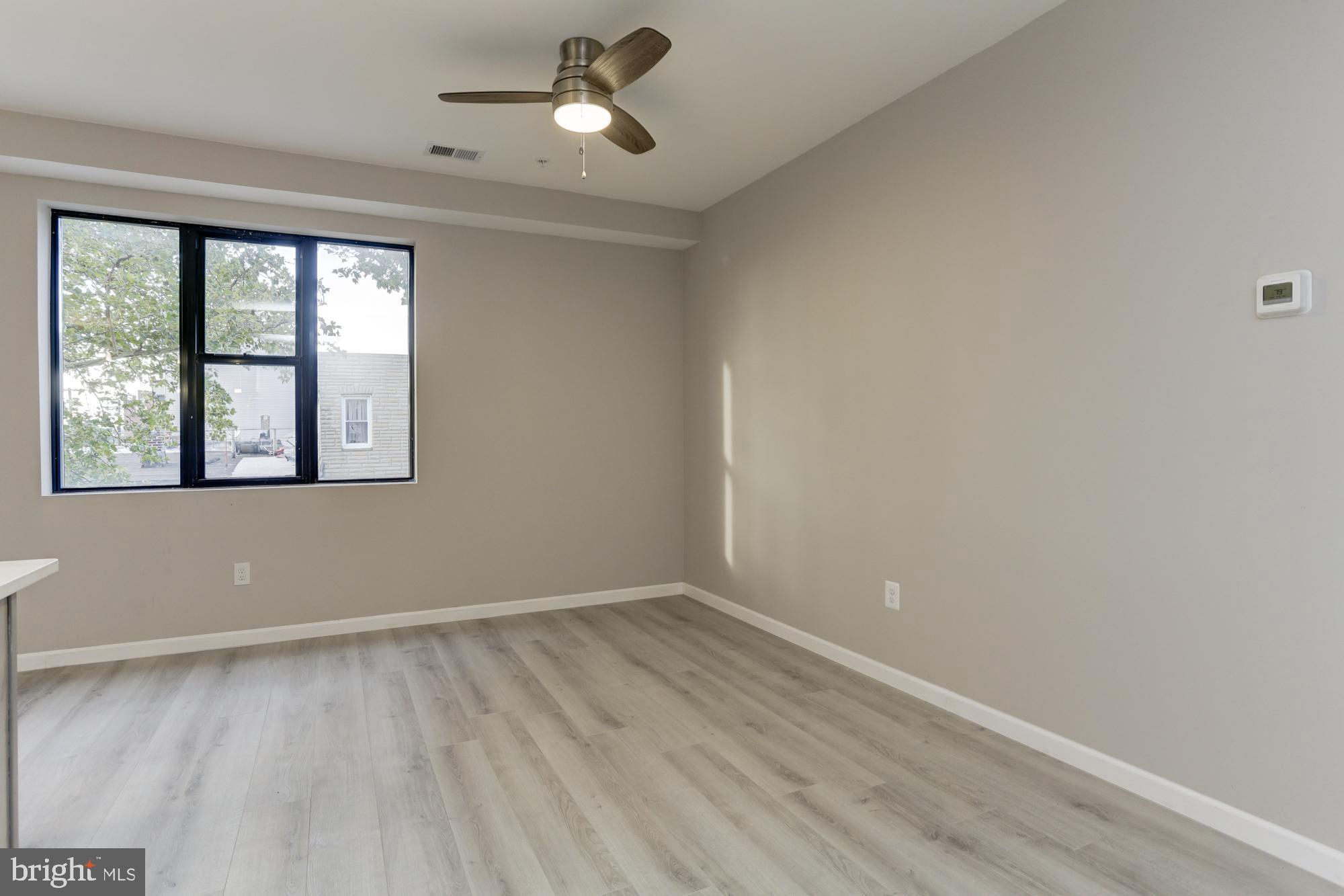 400 South Highland Avenue, Unit 301 Baltimore, MD 21224 - Photo 5 of 13 wooden floor in an empty room with a window