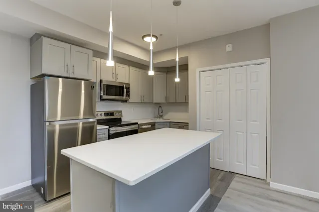 a kitchen with stainless steel appliances a refrigerator sink and microwave