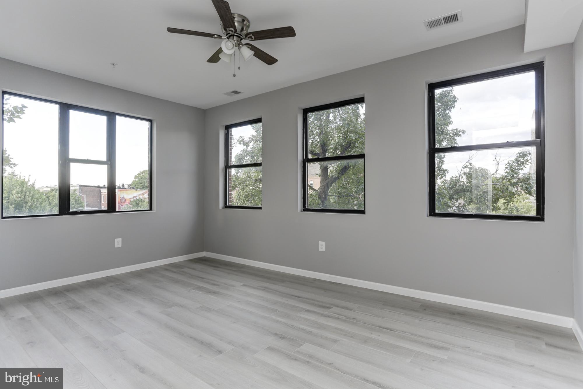400 South Highland Avenue, Unit 301 Baltimore, MD 21224 - Photo 9 of 13 a view of an empty room with a window and wooden floor