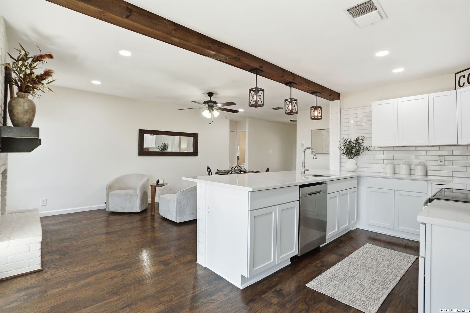 7106 Comanche Ridge Drive Converse, TX 78109 - Photo 21 of 36 a kitchen with a sink dishwasher a stove and white cabinets with wooden floor
