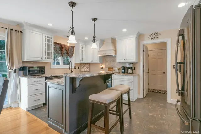 a kitchen with kitchen island white cabinets and stainless steel appliances