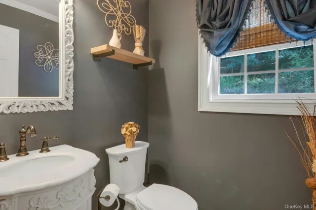 a bathroom with a toilet a sink and a window