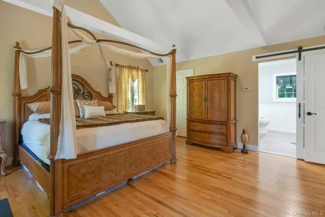 a view of front door with hallway and wooden floor