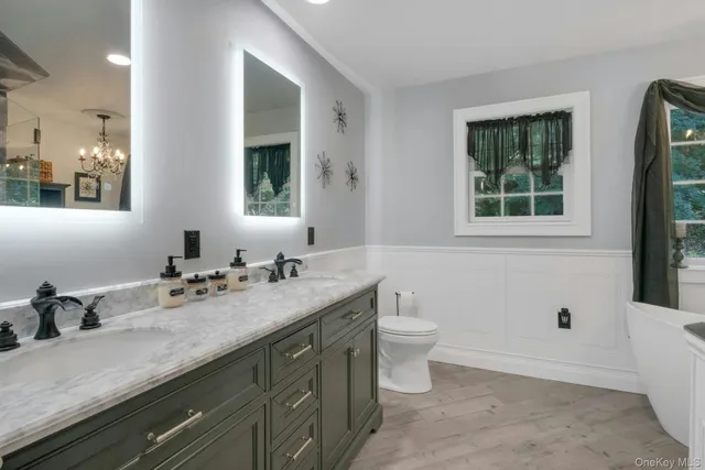 a bathroom with a granite countertop sink a toilet and a mirror