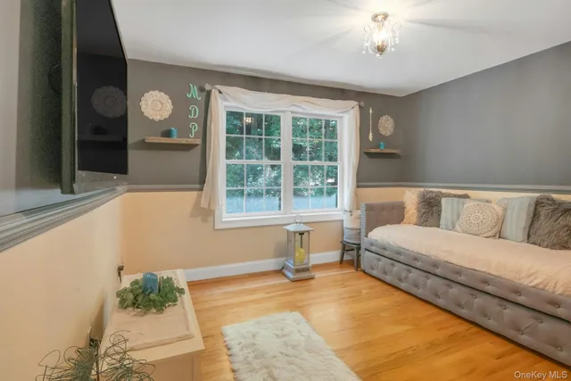 a living room with a bed furniture and a large window