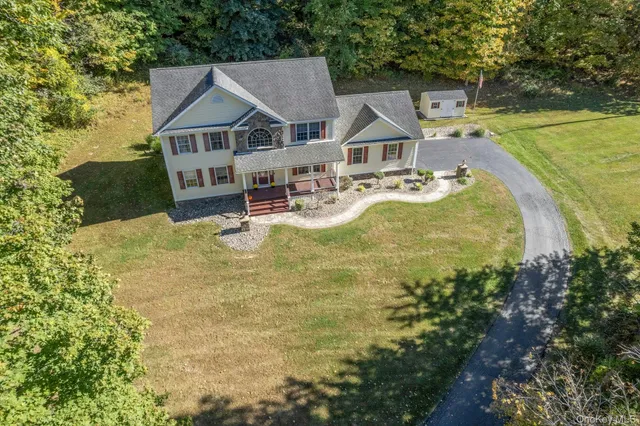 a white house with a big yard and large trees
