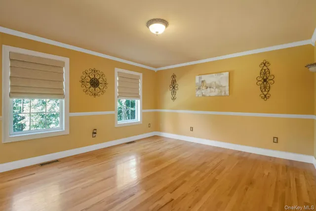 a view of empty room with window and wooden floor