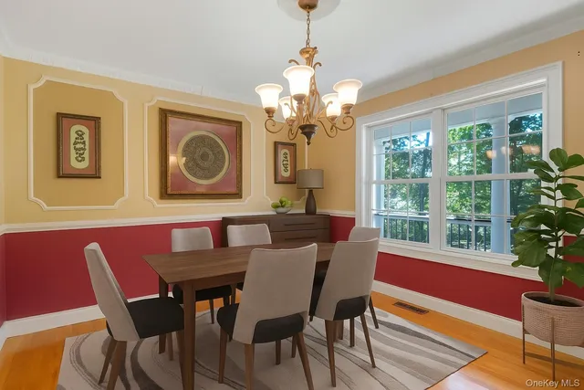 a view of a dining room with furniture a chandelier and wooden floor