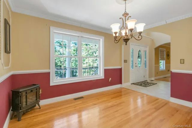 a view of an empty room with a chandelier fan and a window