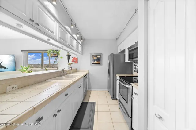 a view of a patio with table and chairs potted plants with wooden wall