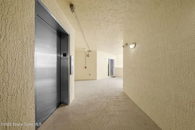 a view of a livingroom with wooden floor and a hallway