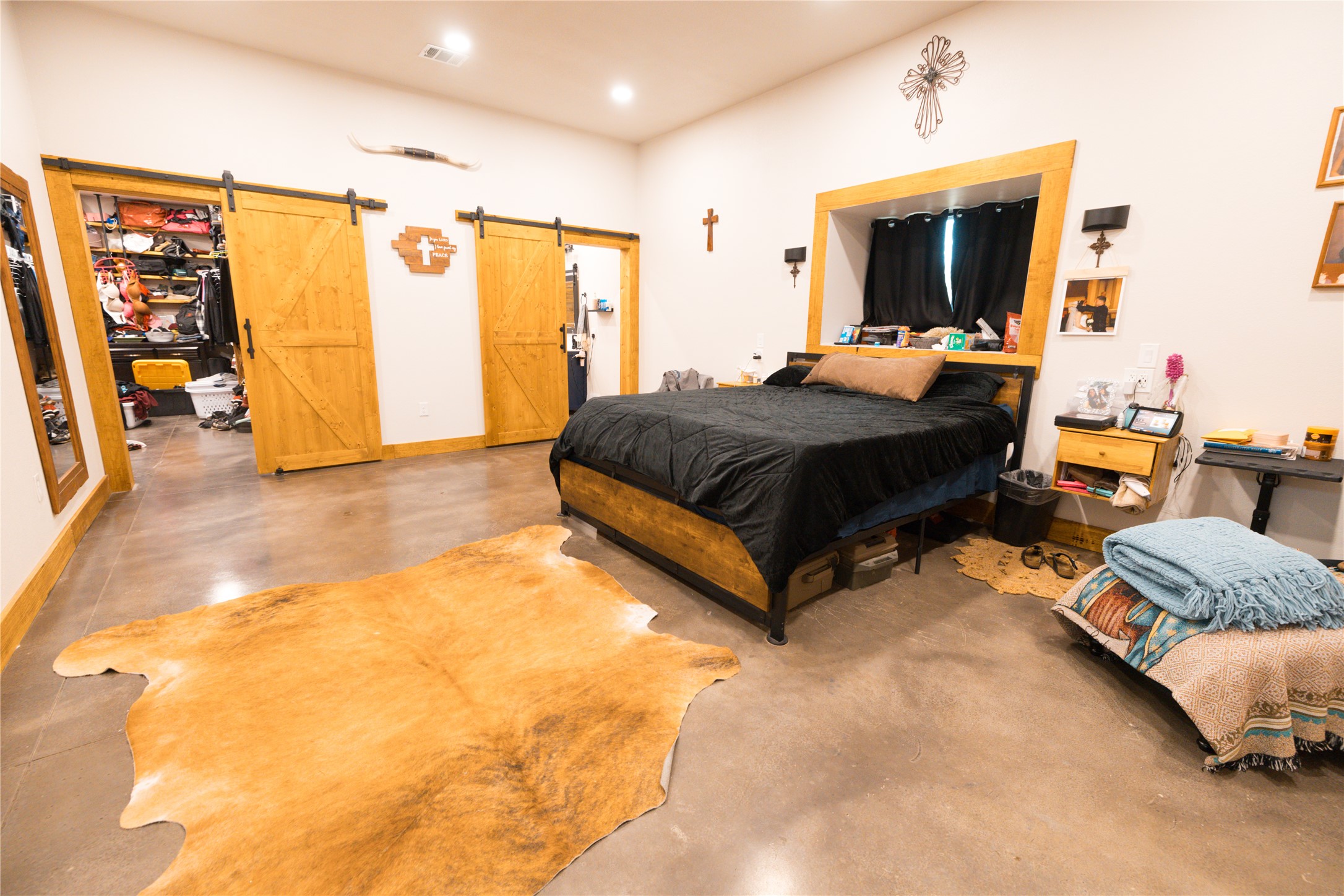 143 County Road Paige, TX 78659 - Photo 19 of 36 Master Bedroom featuring concrete floors, a barn door, and recessed lighting