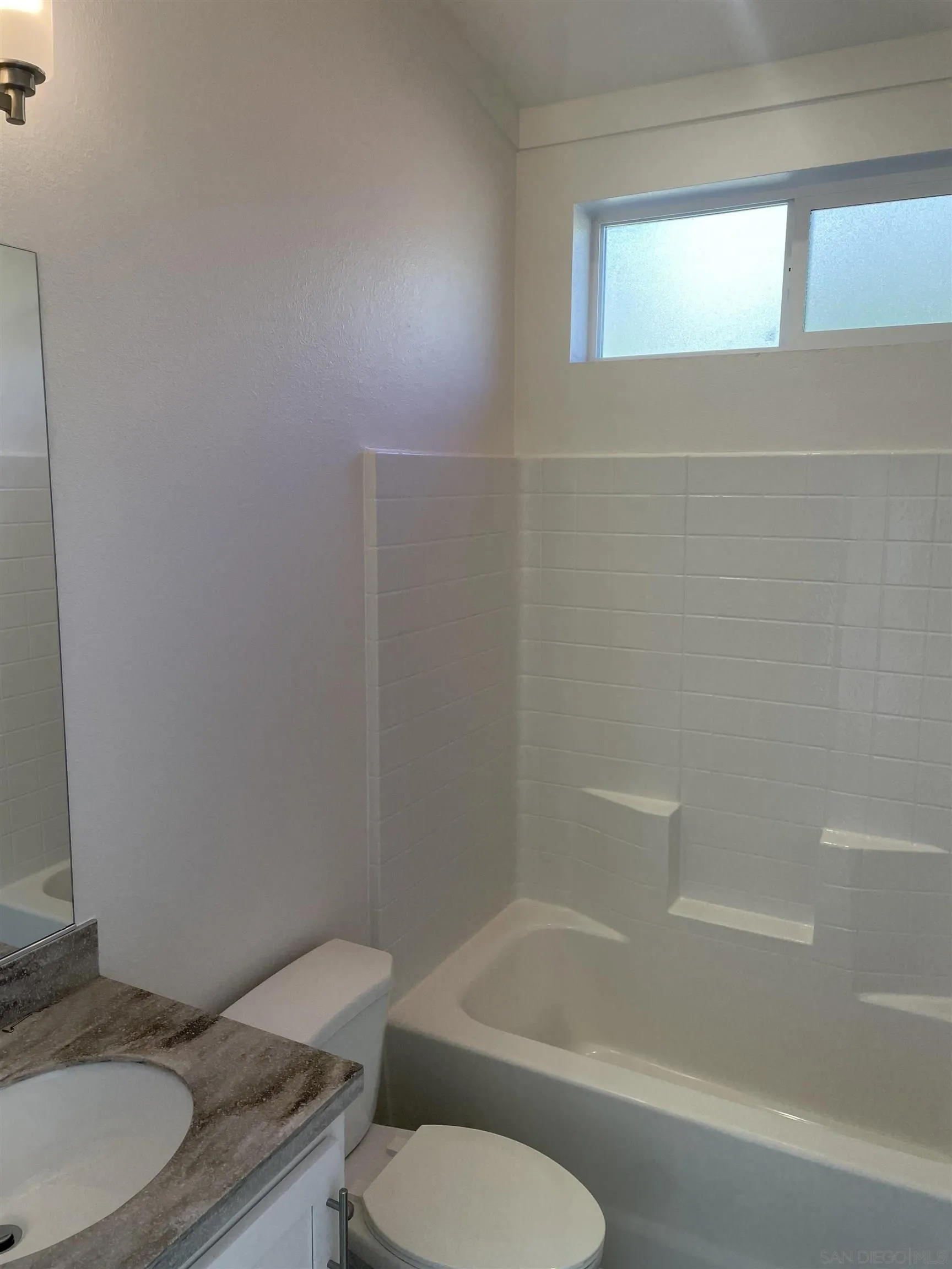 1255 Rhea Place, Unit B Vista, CA 92084 - Photo 11 of 13 a bathroom with a granite countertop toilet a sink and bathtub