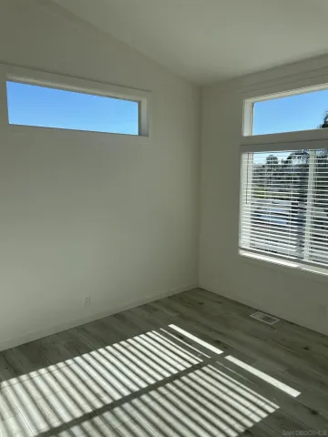 a view of a room with wooden floor and a window