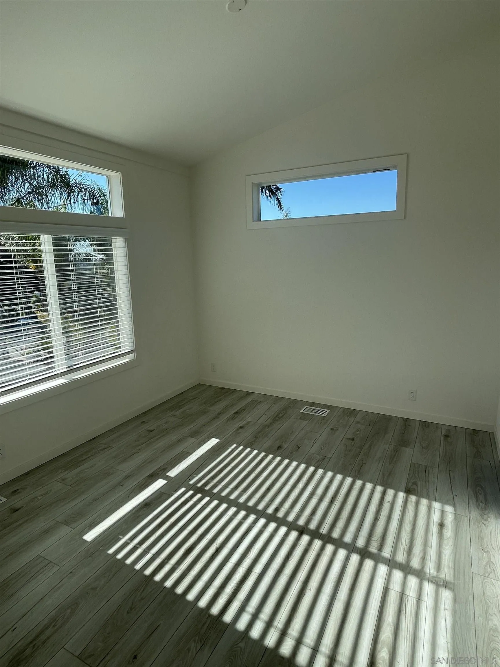 1255 Rhea Place, Unit B Vista, CA 92084 - Photo 4 of 13 a view of an empty room with wooden floor and a window