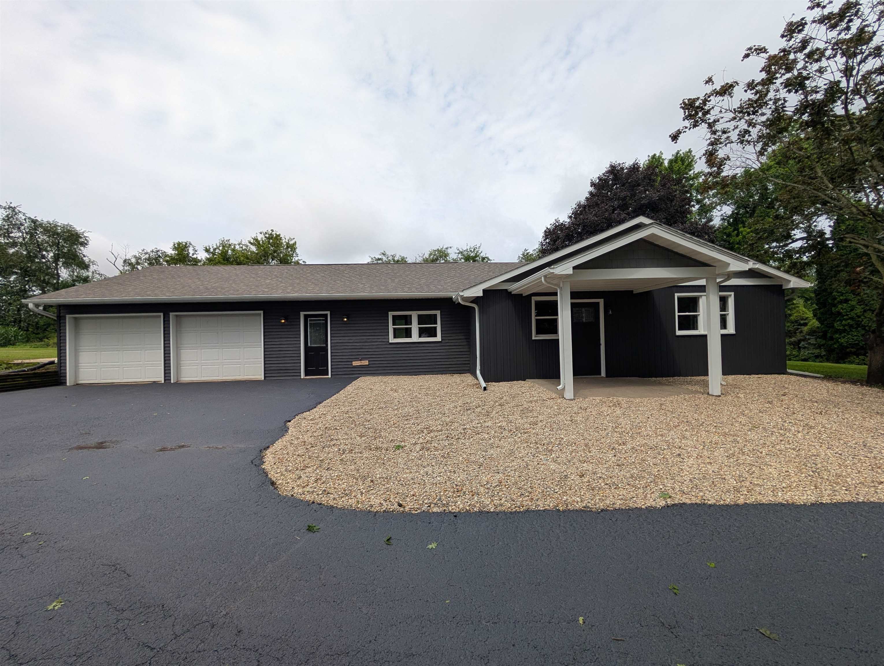 14202 Fritz Road Durand, IL 61024 - Photo 1 of 20 a front view of a house with a garden and garage