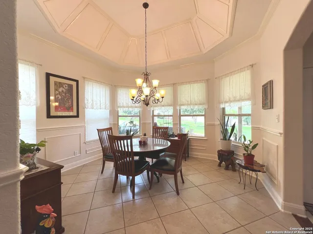 a living room with furniture a flat screen tv and kitchen view