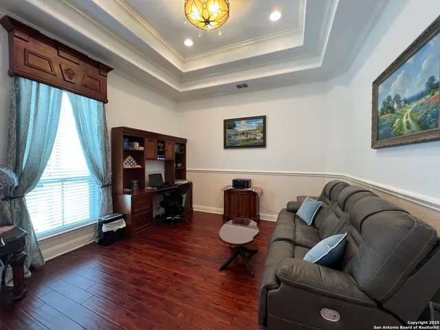 a living room with a bed furniture and a flat screen tv