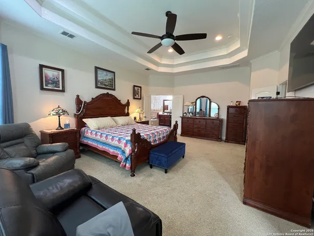 a view of a workspace with furniture and a ceiling fan