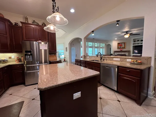 a kitchen with stainless steel appliances granite countertop wooden cabinets a stove top oven a sink and dishwasher