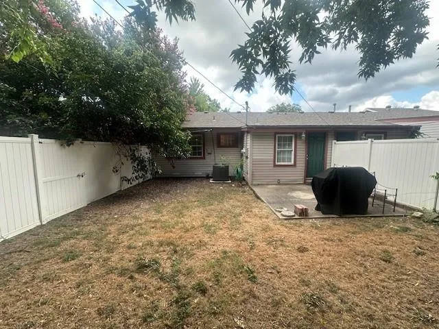 a view of a house with a backyard and a tree
