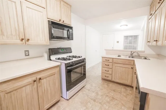 a kitchen with white cabinets and appliances