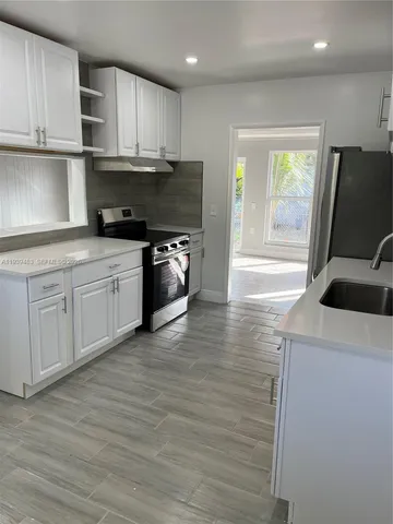 a kitchen with stainless steel appliances granite countertop a sink a stove and a refrigerator